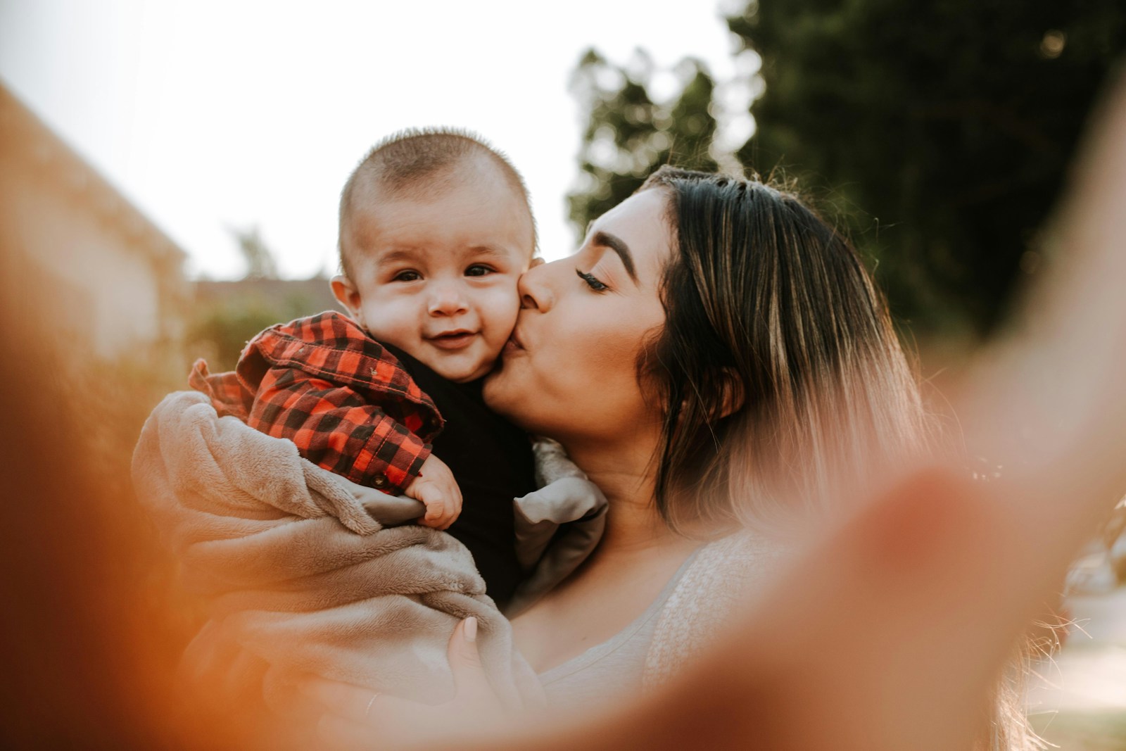 woman kiss a baby while taking picture, life and health